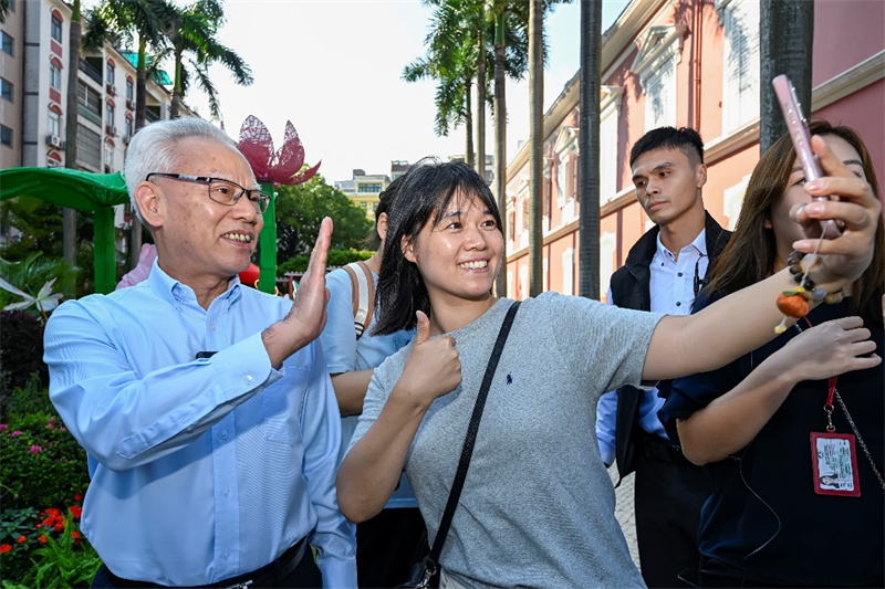 图为游客在政府总部开放日活动中见到岑浩辉并合影，游澳收获倍增。澳门特区政府新闻局供图